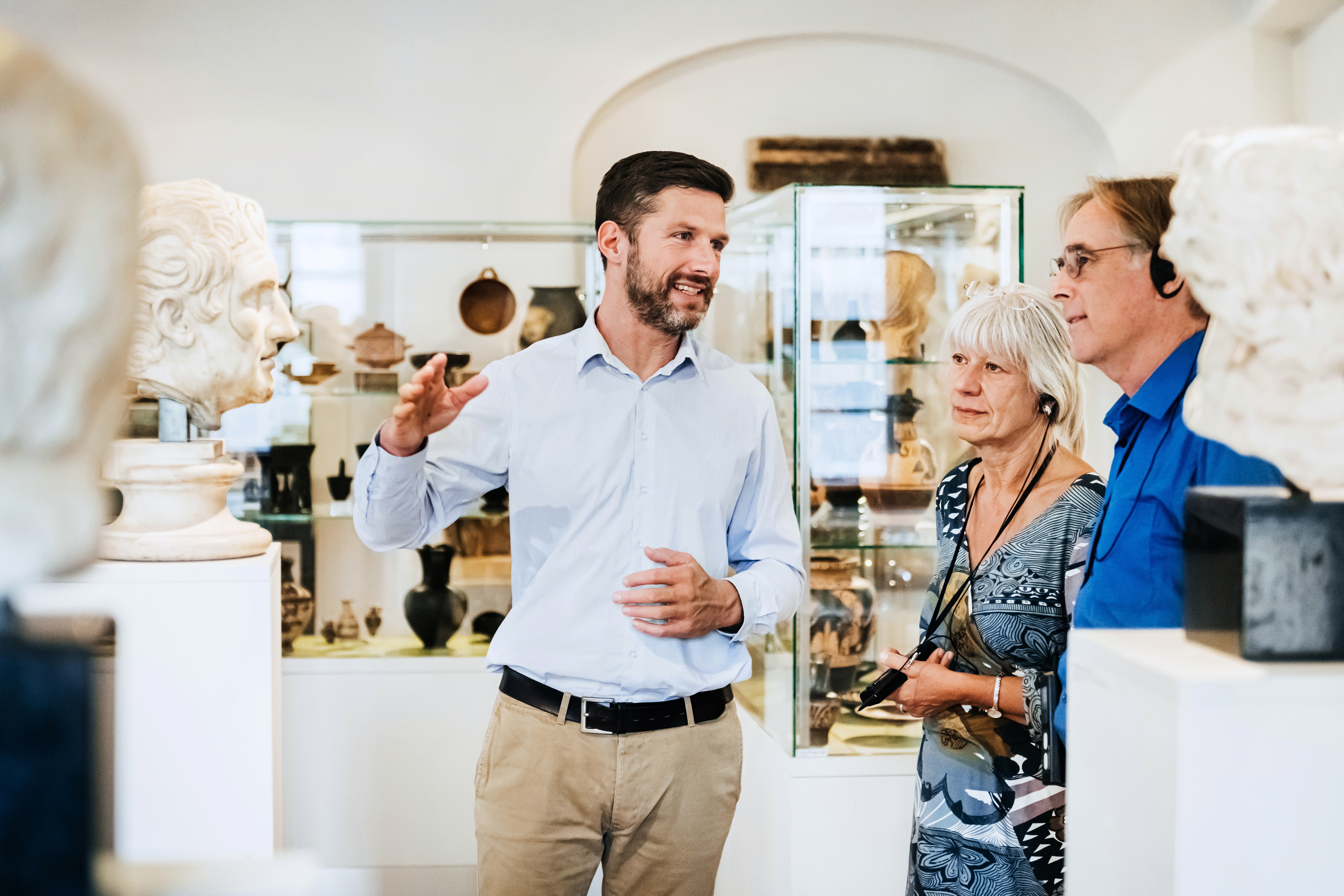 Discover how AI is reshaping nonprofits, optimizing fundraising, conservation, and resource allocation. Pictured is a museum worker showcasing off exhibits to an older couple.