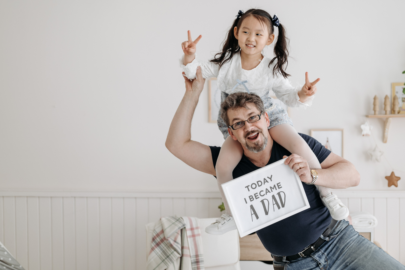 A Father holds a photo that says "Today I Became a Dad" with his young, approximately five year old daughter sitting on his shoulders. Effective data management in Sparkrock 365's ERP can assist family services organizations thrive.