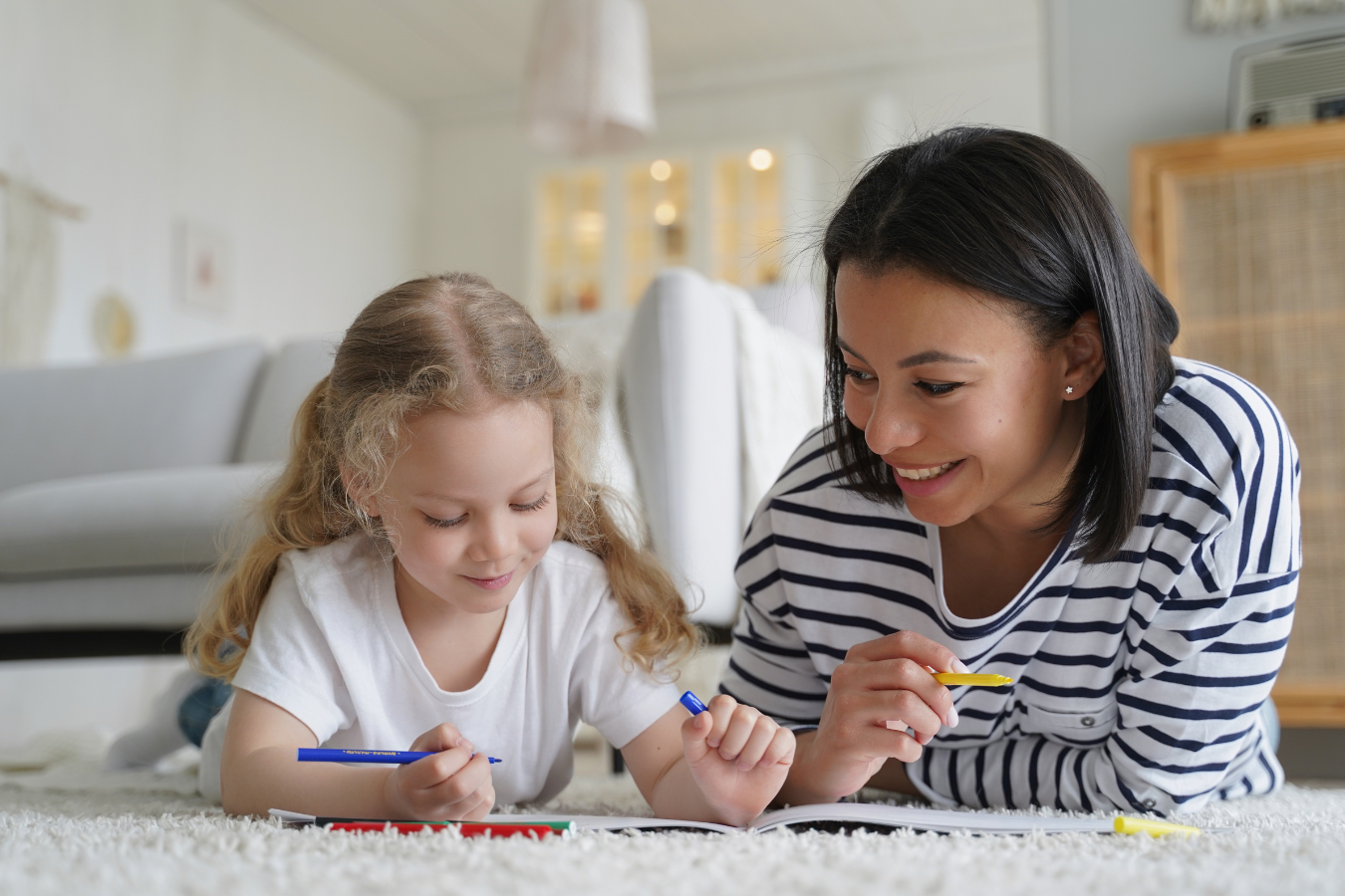A foster care Mother helps her young foster care daughter colour. The two are smiling and happy. Sparkrock's ERP tool is an invaluable resource for social services providers.