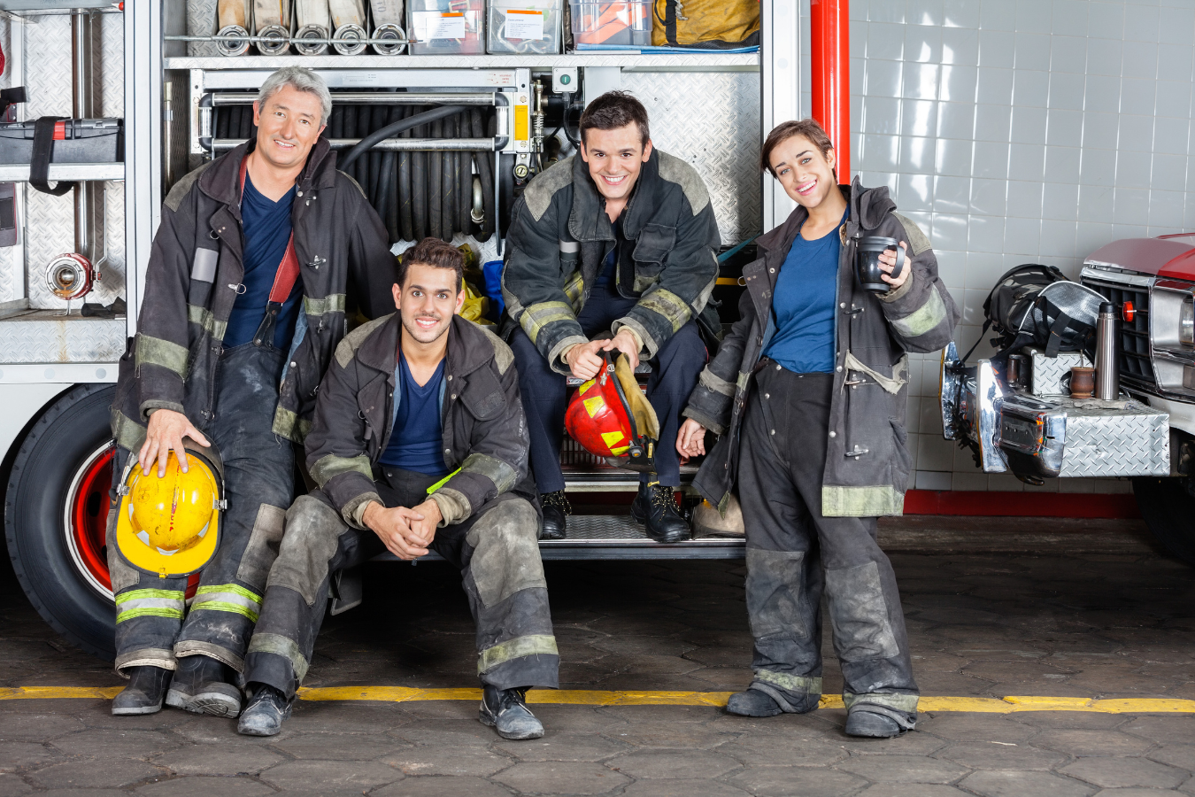 Firefighters smiling, sitting on their firetruck. Public safety organizations can be optimize their organizations through the use of public safety ERP software like Sparkrock 365.