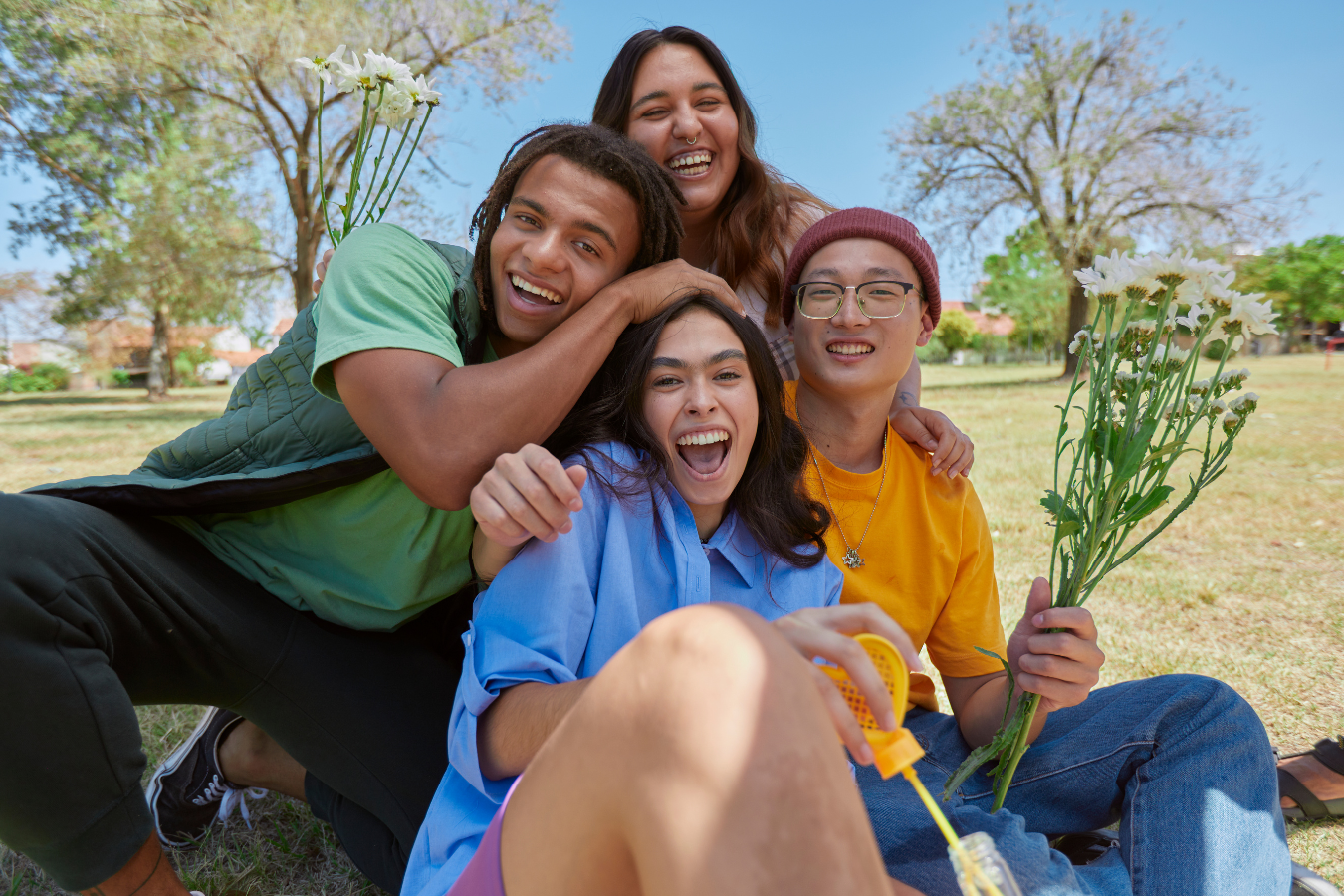 Four multicultural youth happily spending time together. Youth development centers using Sparkrock 365 ERP are more efficient, allowing increased focus on youth development and community building.