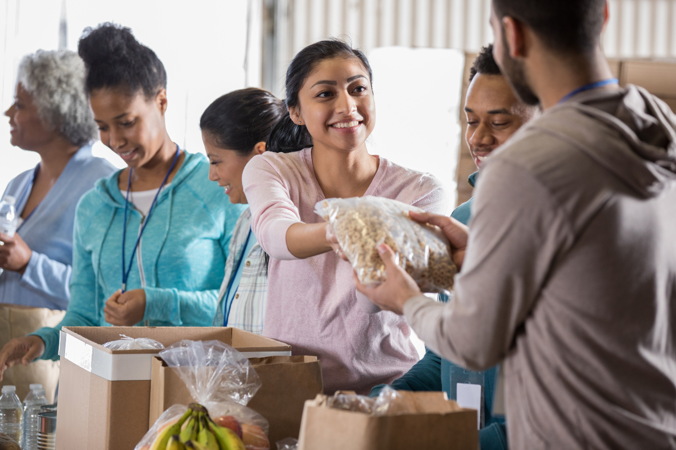 A group of volunteers hand out food to those in need while they help a charity nonprofit. ERPs for nonprofits and charities help reduce manual tasks.