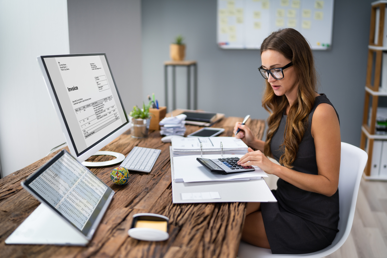 Accountant works on her calculator at her desk. Sparkrock 365, an ERP platform designed for nonprofits, can help organizations transition from the sunsetting transition of QuickBooks Desktop 2021 and Microsoft GP.