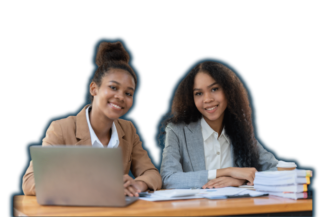 Two smiling professionals sitting at a desk with a laptop, documents, and a coffee, representing confident decision-making through data and reporting tools.