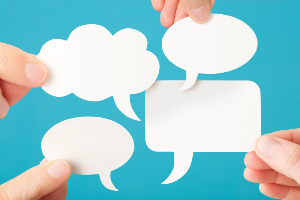 Hands holding speech bubbles, representing the key conversations finance teams need before redesigning nonprofit ERP dimensions