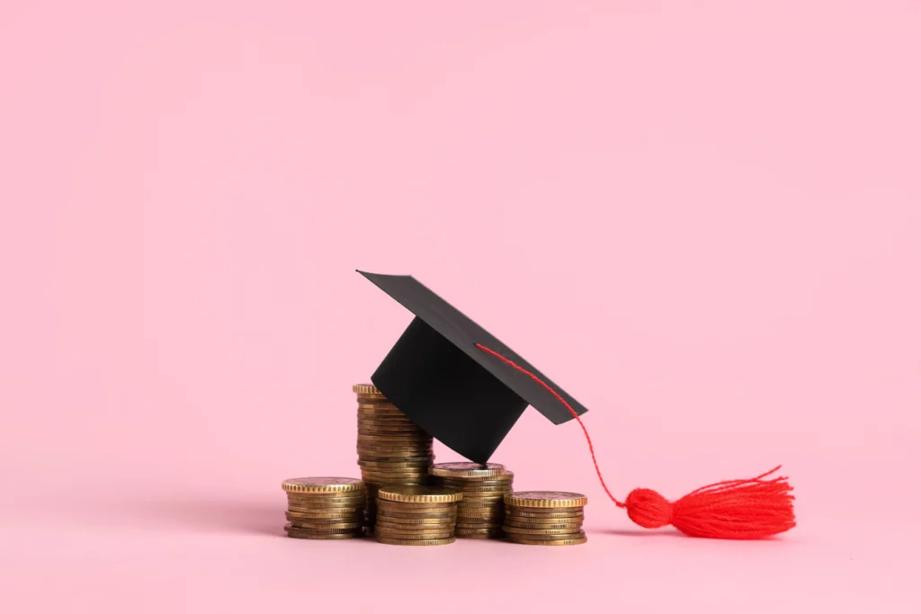 Graduation cap resting on stacked coins symbolizing connected K–12 ERP systems, school payments, and financial management.