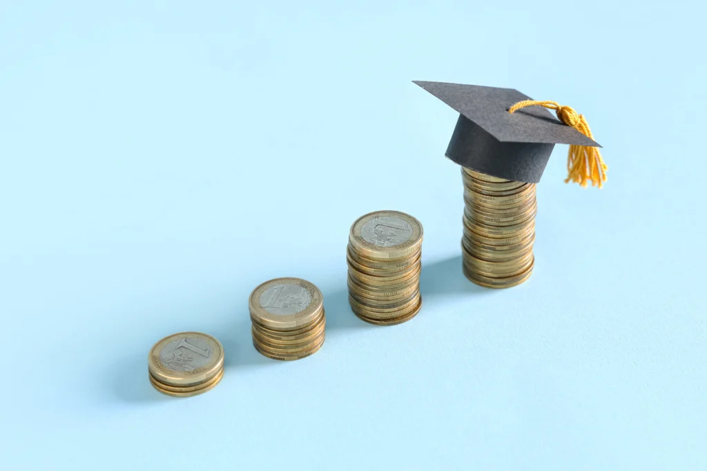 Stacks of coins increasing in size with a graduation cap on top, representing school-generated funds and financial growth in school accounting