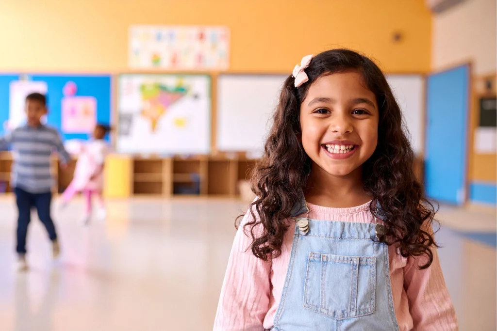 Smiling young student in a bright classroom, representing a positive and supportive school environment