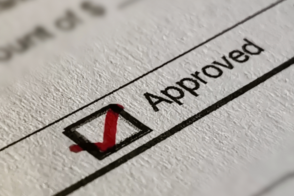 Close-up of a paper approval checkbox with a red checkmark, representing manual purchase approval processes in nonprofit organizations