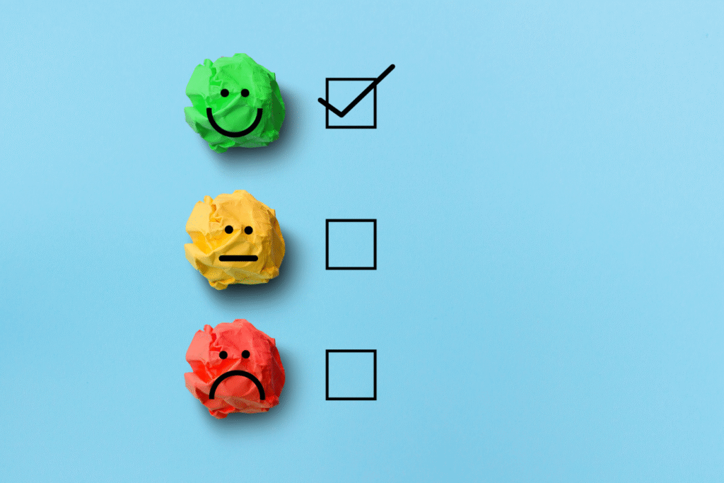 Green, yellow, and red crumpled paper smiley faces beside checklist boxes, with only the green option checked, representing evaluating and choosing activity fund software.